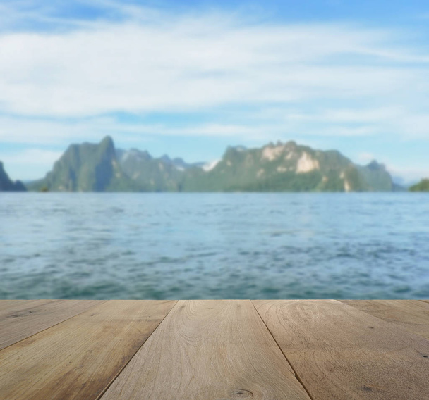 山や湖のあるぼやけた美しい景色の上の木のテーブル - 写真・画像