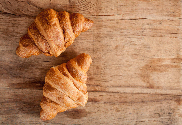 Čerstvý croissant na dřevěný stůl - Fotografie, Obrázek