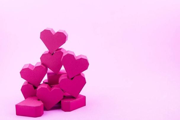 Pila de caja de papel rojo forma de corazón sobre fondo rosa con copia
  - Foto, imagen