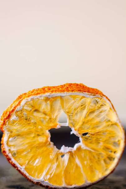Сушений апельсин на чорному металевому столі на білому тлі
 - Фото, зображення
