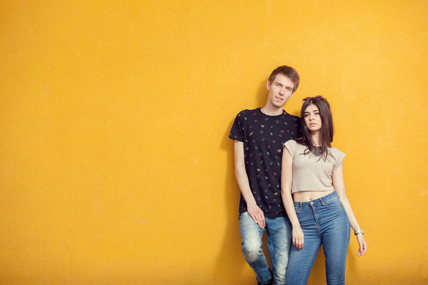 Paar posiert modisch auf gelber Wand - Foto, Bild