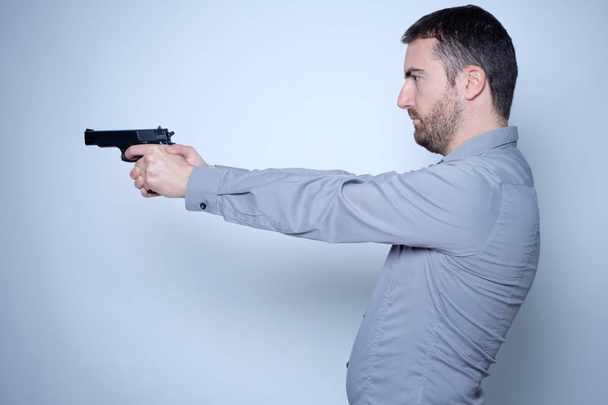 Un homme tenant une arme dans ses mains prêt à tirer
 - Photo, image