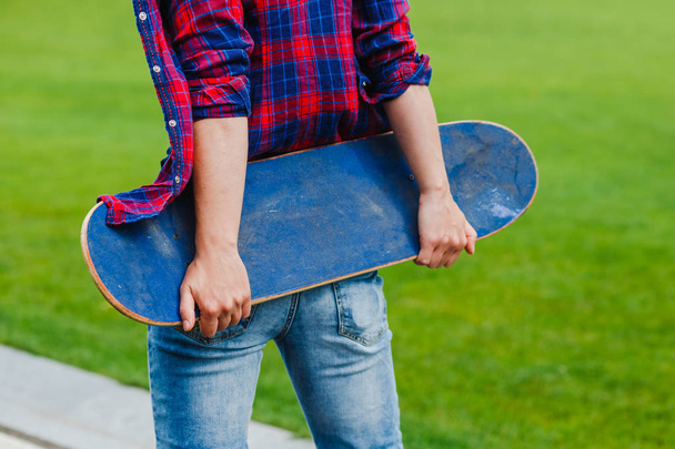 Hipster girl on rural road holding a skateboard in hands - Foto, imagen