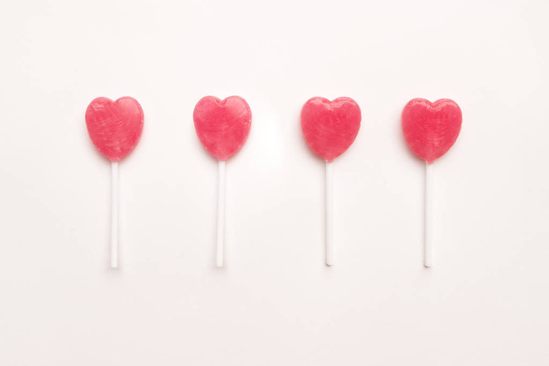 čtyři růžový Valentýnský den srdce tvar lízátko candy uspořádat na pozadí prázdný dokument white paper. Pojetí lásky. Knolling pohled shora. Barevné hipster stylu minimalismu. - Fotografie, Obrázek