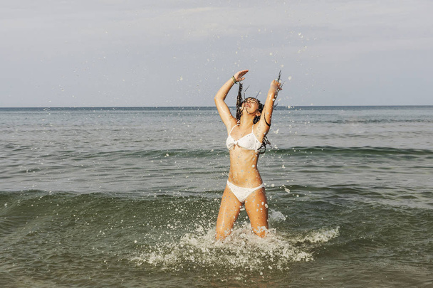 Felice adolescente che gioca con l'acqua sulla riva del mare del bea
 - Foto, immagini