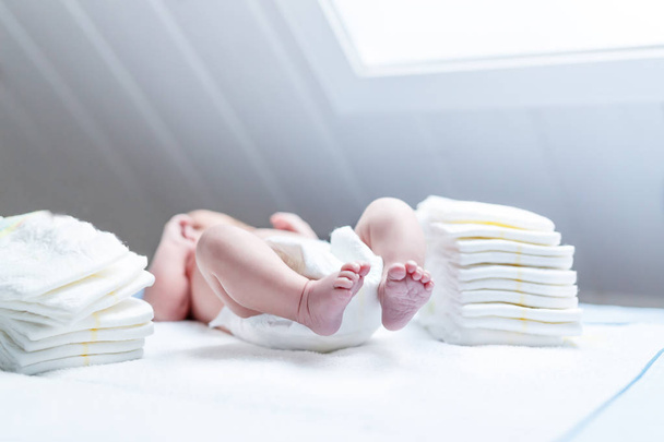 Pieds de nouveau-né sur table à langer avec couches
 - Photo, image