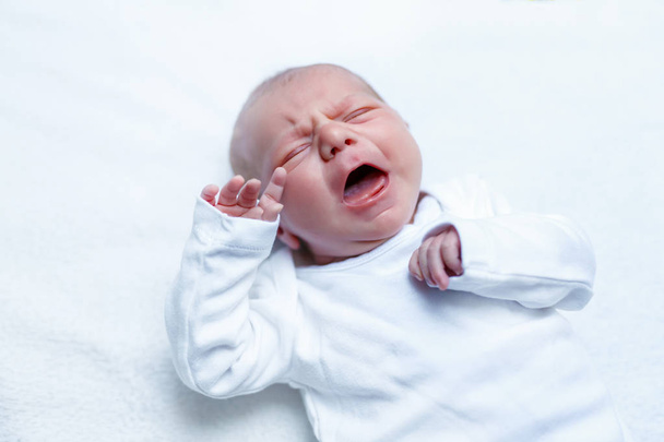 Crying newborn baby boy or girl on changing table - Fotó, kép