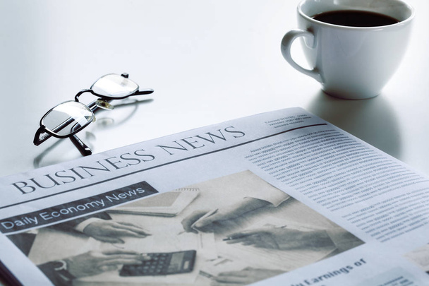 Newspaper with eyeglasses on white table - Foto, imagen