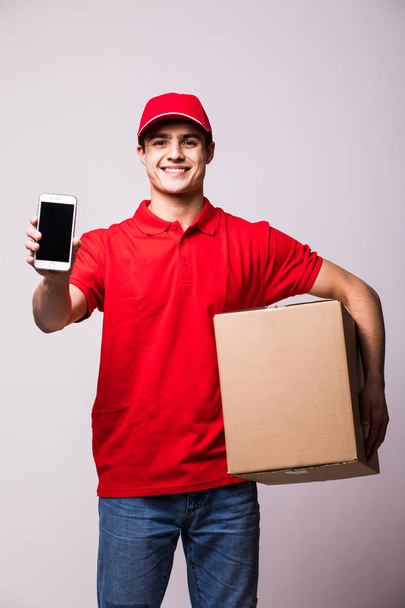 Delivery man with box holding and show phone - Foto, Bild