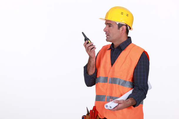 Labourer speaking into a walkie-talkie - Fotoğraf, Görsel