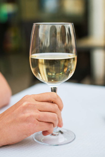 Woman sitting at table with white glass of wine. - Photo, Image