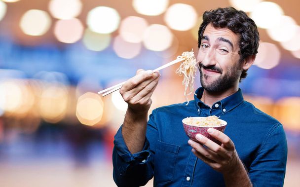man eating sushi from noodles pot - Фото, зображення
