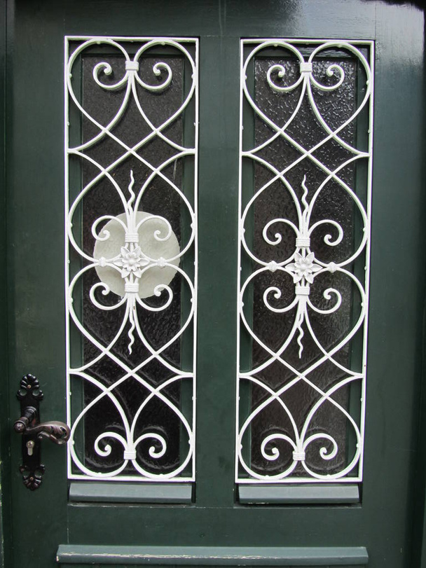 Puerta verde con una celosía decorativa tallada ligera
. - Foto, Imagen