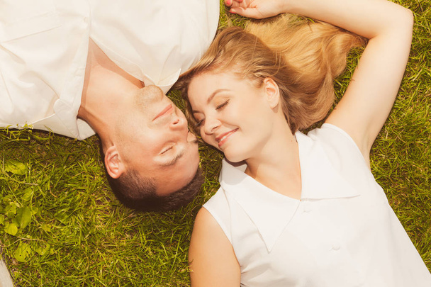 Man and woman lying on grass having date - Фото, изображение
