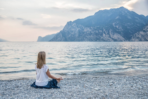 Woman meditating at the lake - Φωτογραφία, εικόνα
