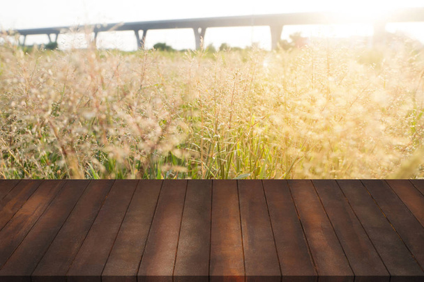 prateleiras de madeira vintage no prado desfocado com flor de grama
. - Foto, Imagem