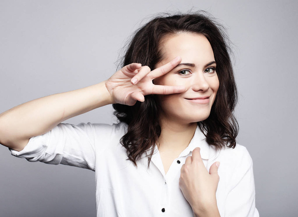 young lovely woman showing victory or peace sign - Foto, afbeelding
