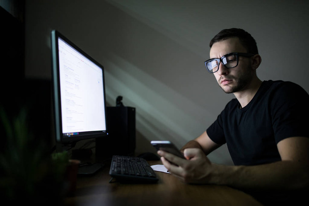 Ο άνθρωπος που εργάζεται στον υπολογιστή τη νύχτα - Φωτογραφία, εικόνα