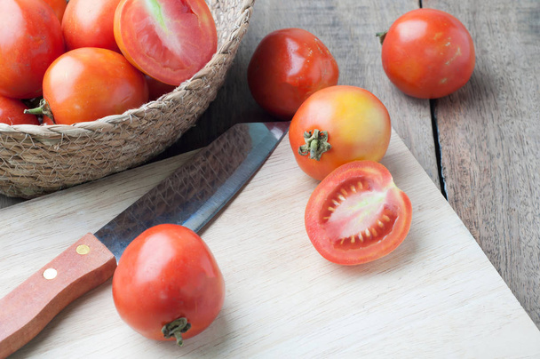 kitchen table with slice fresh tomatoes on wood basket. - Fotó, kép