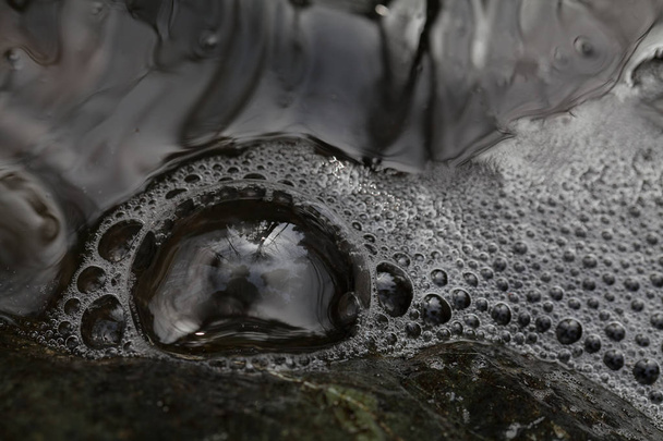 stone under the sparkling mountain water, note shallow depth of field - Photo, Image