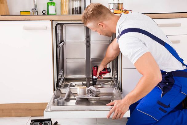 Repairman Fixing Dishwasher - Foto, Imagen