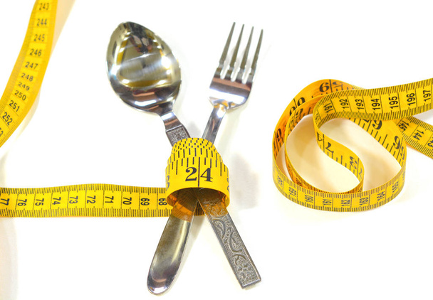 Cuchara de acero, tenedor y cinta métrica
 - Foto, Imagen
