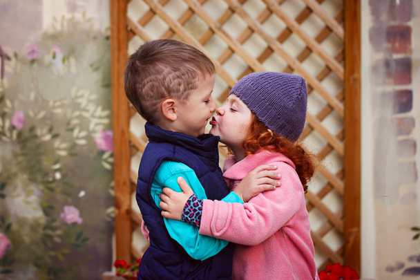 Little girl kissed for the first time adorable little boy. Love and romantic concept - Zdjęcie, obraz