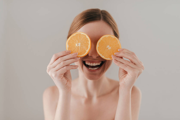 Beautiful woman holding orange slices - Foto, imagen