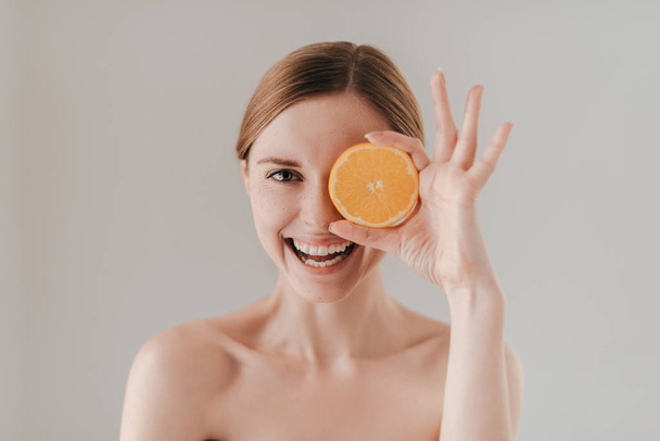 Bella donna che tiene fetta arancione
 - Foto, immagini