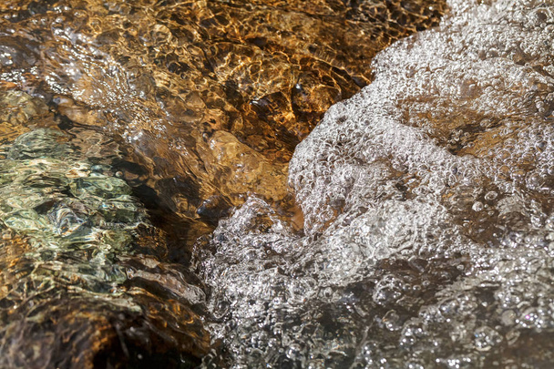 pietra sotto l'acqua di montagna, nota profondità di campo poco profonda
 - Foto, immagini
