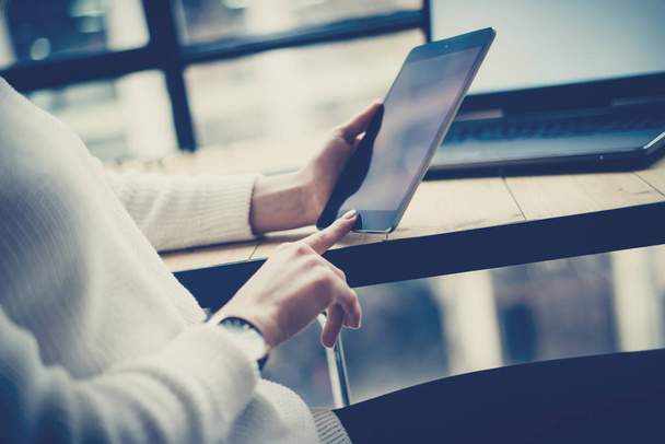 デジタル タブレットの木製の机の上のボタンに触れる女性の手のクローズ アップ ビュー。コンセプト若いビジネス人がモバイル デバイスを使用して。水平にぼかした背景. - 写真・画像