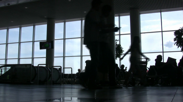 σιλουέτες των κατά των windows σε μια αίθουσα αεροδρόμιο - Πλάνα, βίντεο