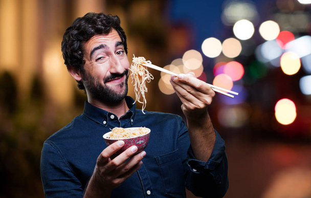 man eating sushi from noodles pot - Zdjęcie, obraz