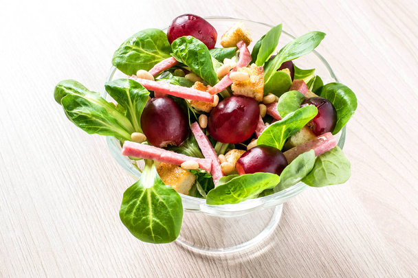 Salade avec salade de maïs frais, raisins, saucisses et croûtons
  - Photo, image