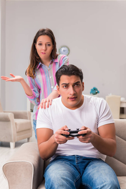 Νεαρή οικογένεια που υποφέρει από εθισμό στα ηλεκτρονικά παιχνίδια - Φωτογραφία, εικόνα