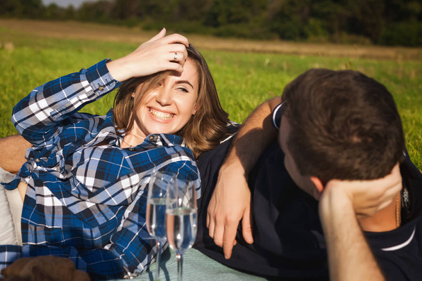 guy with a girl lying on the grass. happy couple in the sunny day - Foto, Imagen