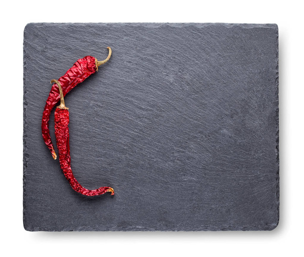 Two dry red pepper on slate blackboard - Photo, image