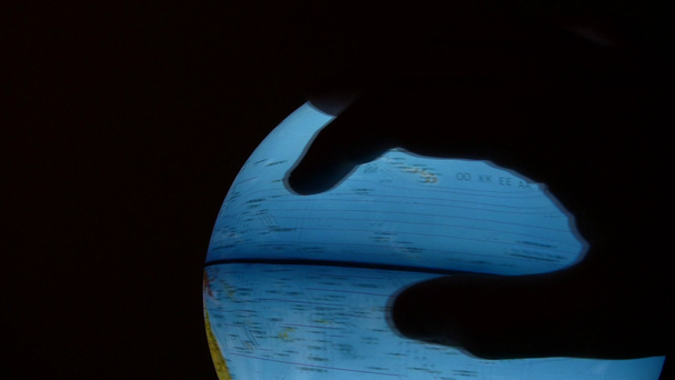 Sziluettjét a kéz forog fényes globe - Felvétel, videó