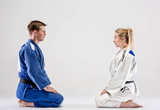 The two judokas fighters posing on gray - Foto, afbeelding