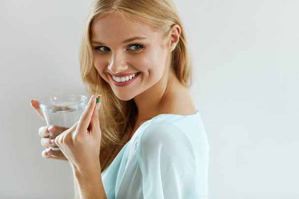 Beautiful Smiling Woman Taking Vitamin Pill. Dietary Supplement - Photo, Image