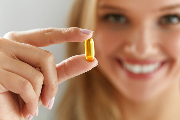 Beautiful Woman Holding Fish Oil Pill In Hand. Healthy Nutrition - Foto, imagen