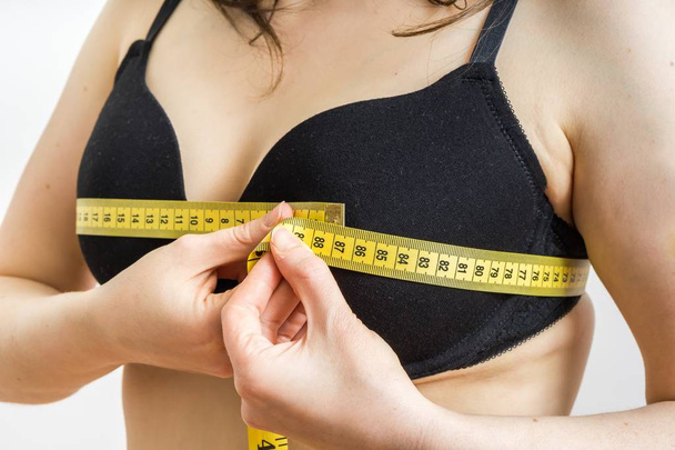 Женщина измеряет размер груди лентой
. - Фото, изображение