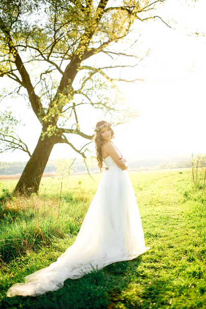 Beautiful bride in wedding dress and with a lovely mood in nature - Φωτογραφία, εικόνα