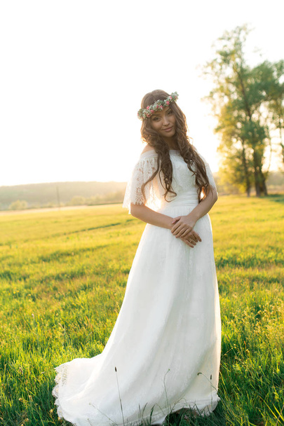 Mooie bruid trouwjurk en met een mooie sfeer in de natuur - Foto, afbeelding