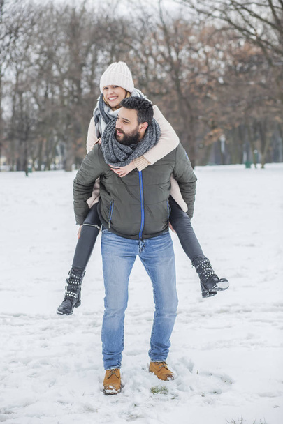 Happy couple walking in winter park  - Zdjęcie, obraz