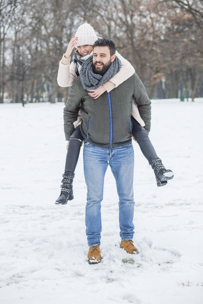 Happy couple walking in winter park  - Φωτογραφία, εικόνα