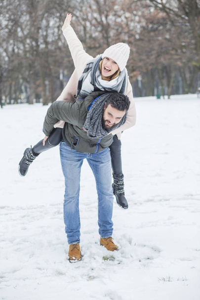 Happy couple walking in winter park  - Foto, Imagen