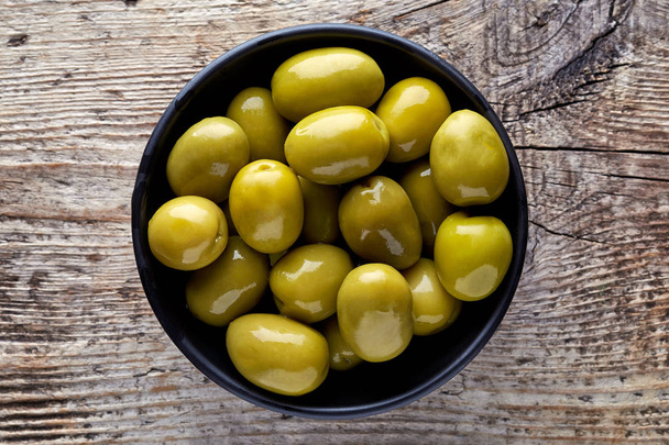 Bowl of green olives from above - 写真・画像