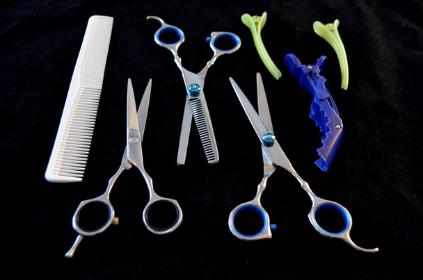 Tijeras y cepillos para el cabello sobre fondo negro
 - Foto, imagen