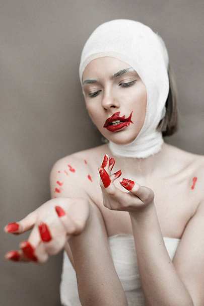 Tyttö, jolla on veriset sormet ja hain huulet. Halloween kauhu käsite. Meluisa kuva. Lisätään viljan koostumus.
 - Valokuva, kuva